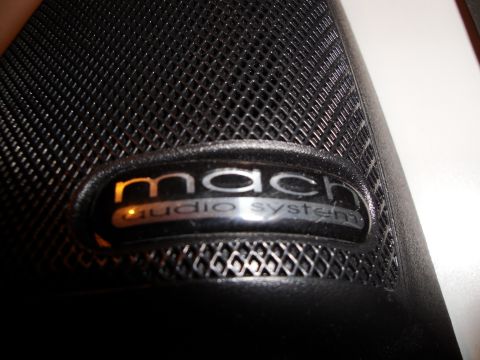 1993 Ford Taurus - Close-up of a Mach audio system emblem on a black speaker grille.