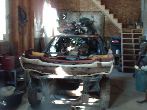 1978 Ford Mustang II - Car body in a state of disassembly inside a garage with various items stored around it.