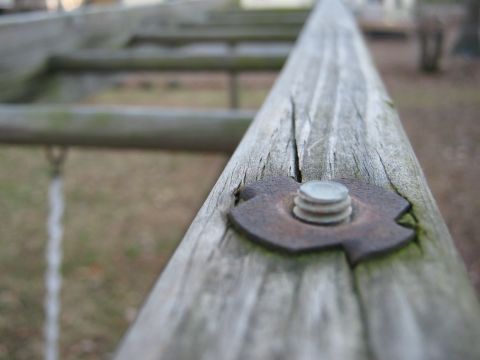 1988 Ford Bronco - A close-up view of a bolt on a wooden structure, with the background out of focus.