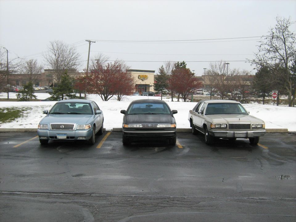 1988 Mercury Grand Marquis parked next to two other sedans in a snowy parking lot