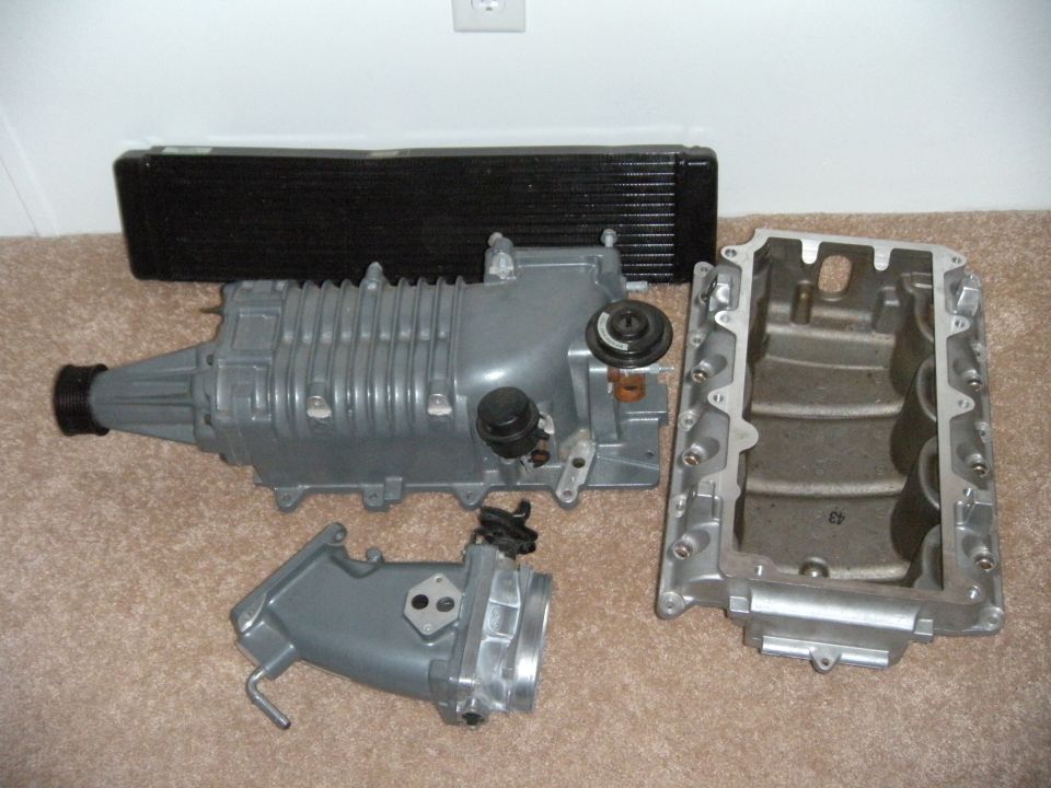 Supercharger, intercooler, and intake manifold laid out on carpet