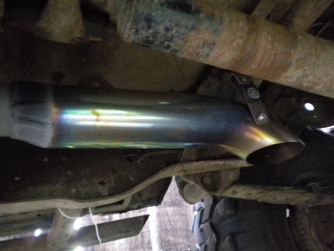 1989 Ford Bronco - Close-up view of an exhaust pipe on a vehicle's undercarriage.