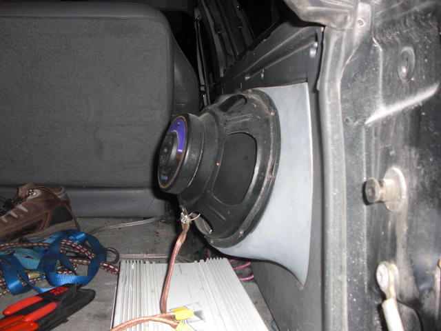 Interior view of a large speaker and amplifier installed in a vehicle