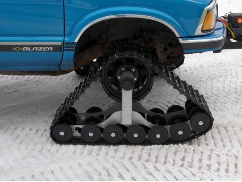 1987 Suzuki Samurai - A blue SUV is equipped with snow tracks instead of wheels for off-road traction.