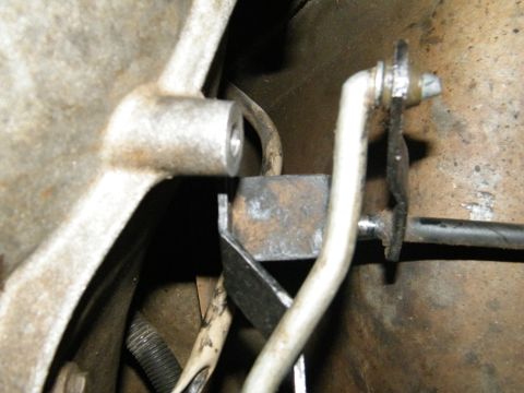 1982 Ford Bronco - Detail view of the mechanical linkage connected to a vehicle's transmission.
