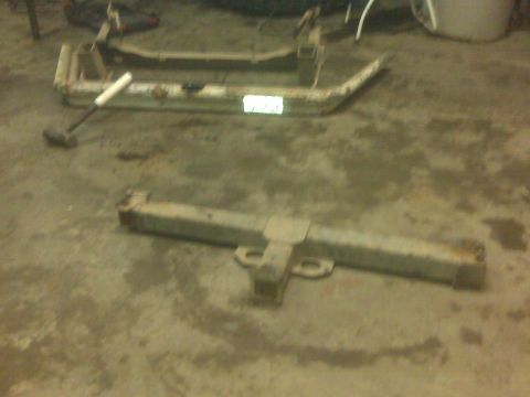 1992 Ford F-350 - Two large metal components, likely truck frame parts or trailer hitches, are on the ground.