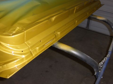 1971 Chevrolet Camaro - A car door, painted in a metallic yellow and blue gradient, rests on a stand in a workshop.