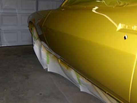 1971 Chevrolet Camaro - A yellow car door is partially masked with tape, suggesting it is undergoing preparation for painting or repair.