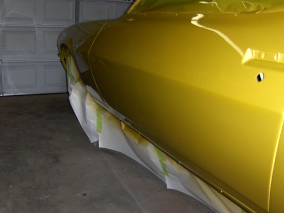 Yellow car door with masking tape on the lower body panels