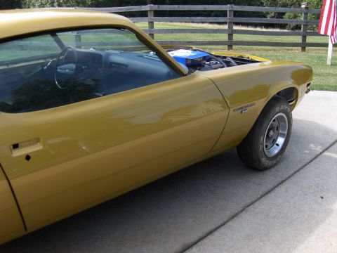 1971 Chevrolet Camaro - A yellow coupe is parked outside with its hood up, revealing the engine and interior.
