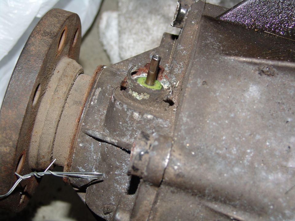 Close-up of a rusty differential housing with a metal pin sticking out