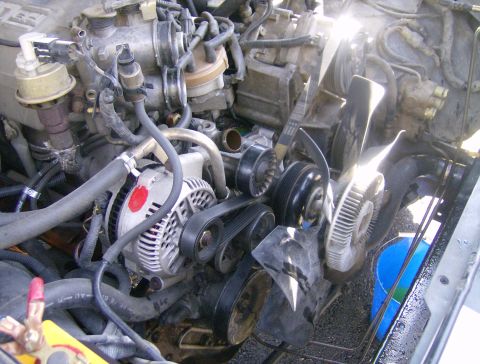 1994 Ford Bronco - Close-up view of an engine bay, showing the alternator, belts, and fan.