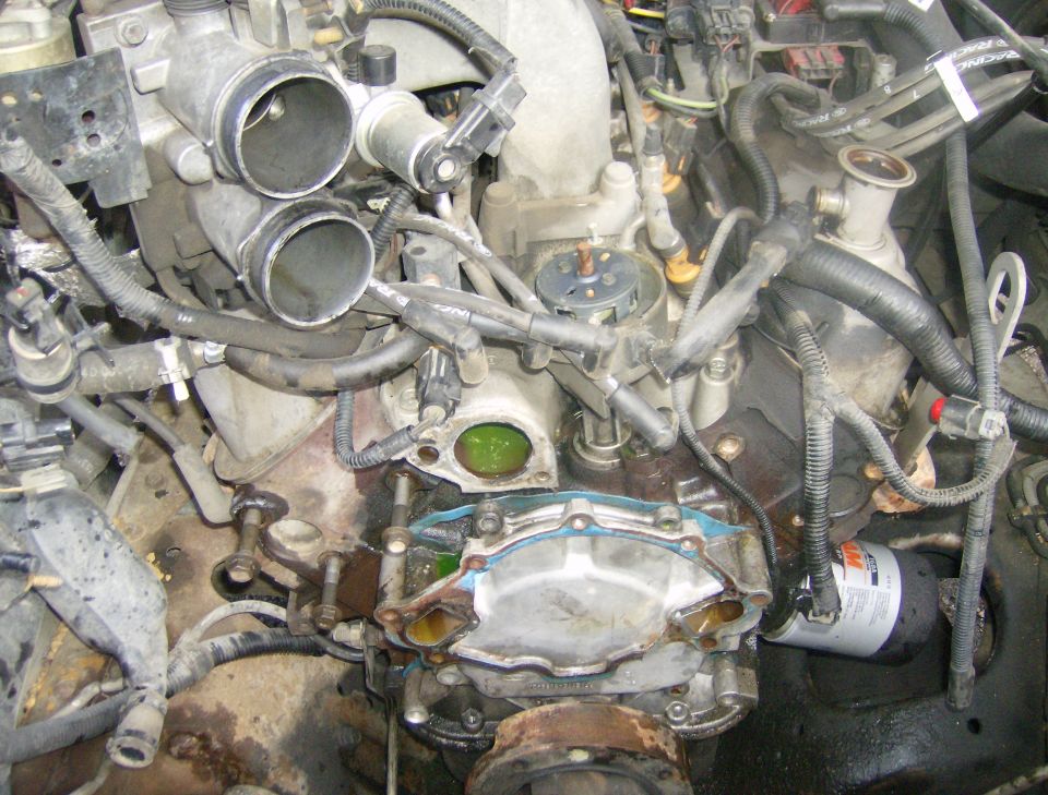 Engine bay with exposed water pump and oil filter. Supermotors.net logo visible