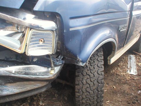 1993 Ford Bronco - Front passenger side of a blue 1993 Ford Bronco shows damage to the fender and headlight assembly.
