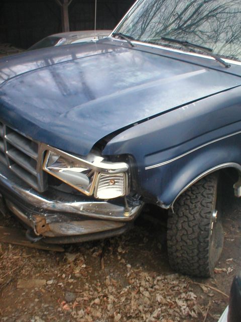 1993 Ford Bronco - Front end damage on a blue Ford truck, likely a 1992 model based on grille design.