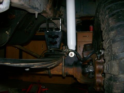 1989 Ford Bronco - Undercarriage view of a vehicle's suspension system, showing leaf springs and a shock absorber.