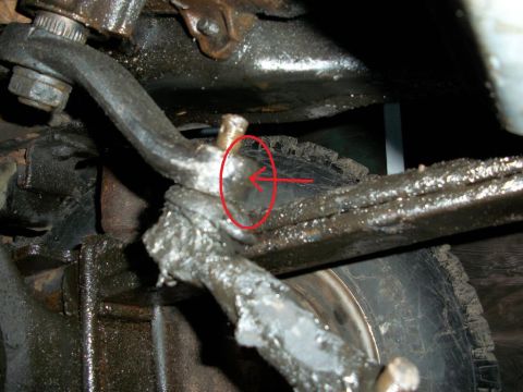 1992 Ford F-350 - Greasy steering linkage component with a red circle and arrow pointing to a pin.