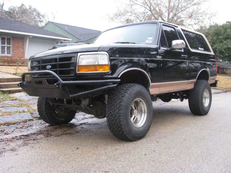 Black Ford Bronco with tan trim and aftermarket bumper, lifted suspension, chrome wheels