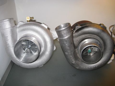 1994 Ford Probe - A comparison of two turbochargers, one appearing new and the other showing signs of use, or being, used.