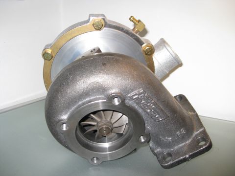 1994 Ford Probe - A turbocharger unit is shown, its metallic construction and internal impeller blades. The "SUPERMOTORS.NET" watermark is visible at the bot…