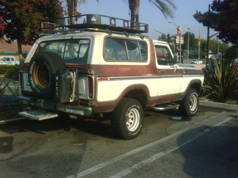 1986 Ford Bronco - This older model Ford Bronco is parked in a lot, showing its rear and side profile.