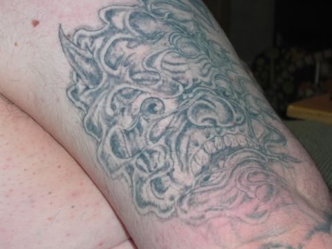 1994 Ford Bronco - Close-up photo of a demon face tattoo on skin.