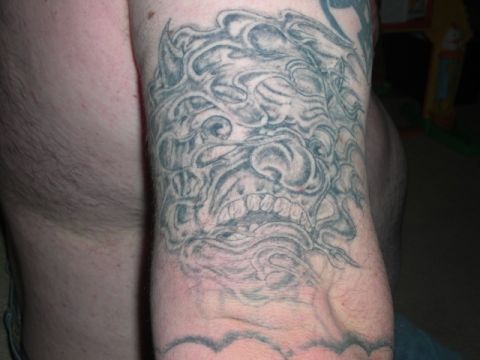 1994 Ford Bronco - A detailed tattoo of a monstrous face with sharp teeth is visible on a person's arm.