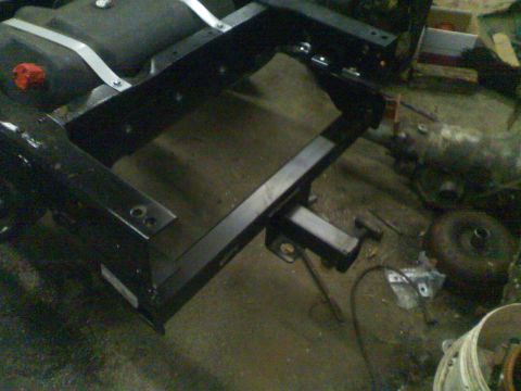 1979 Ford F-250 - A trailer hitch assembly is attached to the frame of a vehicle, with a fuel tank in the background.