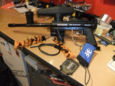 1978 Chevrolet C/K Pickup - A black Tippmann 98 Custom paintball marker is displayed on a table with various accessories.