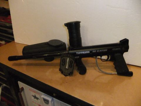 1978 Chevrolet C/K Pickup - A black Tippmann 98 Custom paintball gun is displayed on a wooden surface with a patch and hopper attached.