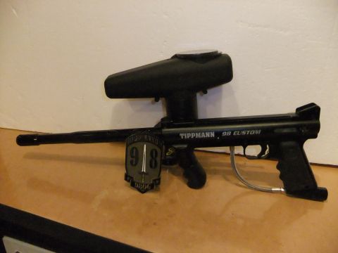 1978 Chevrolet C/K Pickup - Black Tippmann 98 Custom paintball gun with a hopper and a shield emblem on its side.