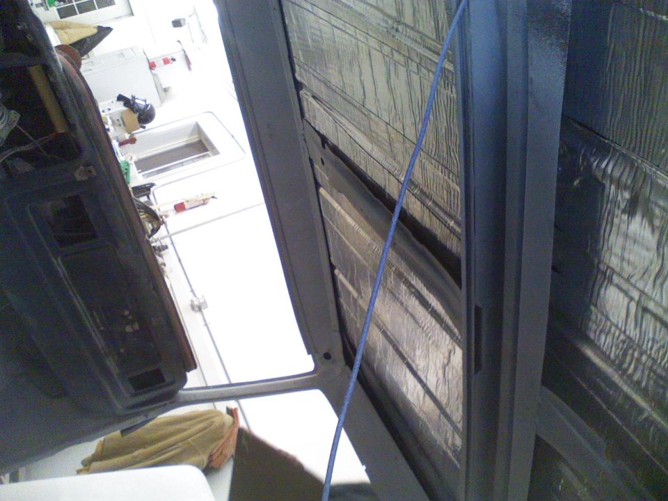 Interior of a vehicle with sound deadening material on the ceiling, viewed from the passenger side