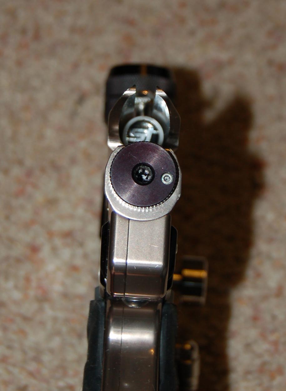 Knurled velocity adjuster with purple face on rear of stainless paintball marker