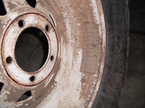1991 Ford Bronco - Wheel and tire assembly with balance weights applied to the rim.