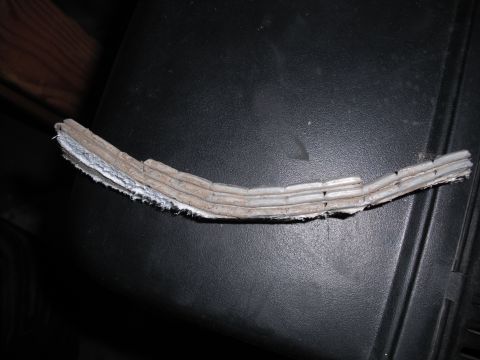 1991 Ford Bronco - A close-up view of a damaged strip of adhesive wheel weights, showing multiple segments.