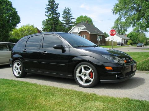 2003 Ford Focus - A black 2003 Ford Focus hatchback is seen from a three-quarter front view, parked on a residential street.