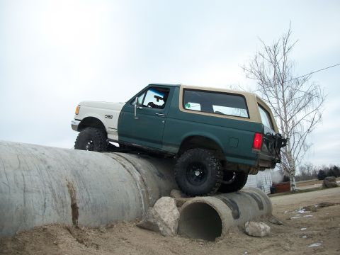 1989 Ford Bronco - This 1989 Ford Bronco navigates a challenging off-road course, climbing over large concrete pipes.