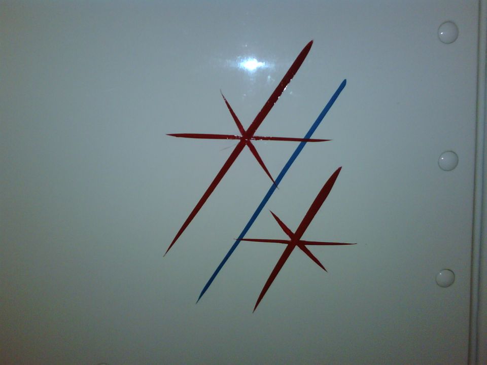 Red and blue paint streaks on a white glossy panel