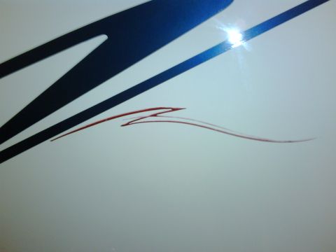 2003 Peterbilt 379 - Close-up of a white truck's side a blue graphic and red pinstripe detailing.