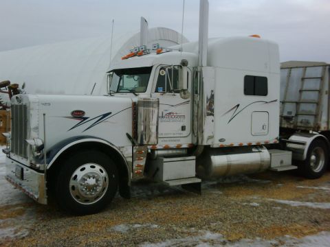 2003 Peterbilt 379 - This 2003 Peterbilt 379 semi-truck is parked outside a large white structure, possibly a barn or warehouse.
