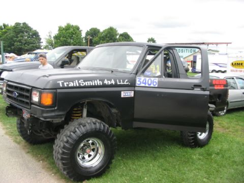 1986 Ford Bronco - Modified 1986 Ford Bronco with large off-road tires and custom decals seen at a truck show.