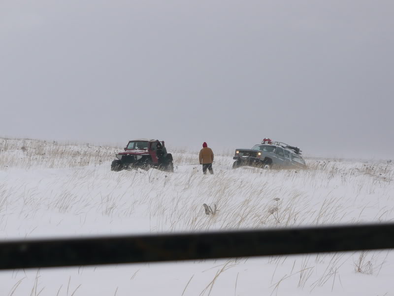 Two off-road vehicles and a person in a snowy field