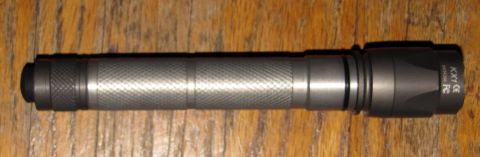 1984 Ford Bronco - A flashlight with visible text markings is shown against a wooden background.