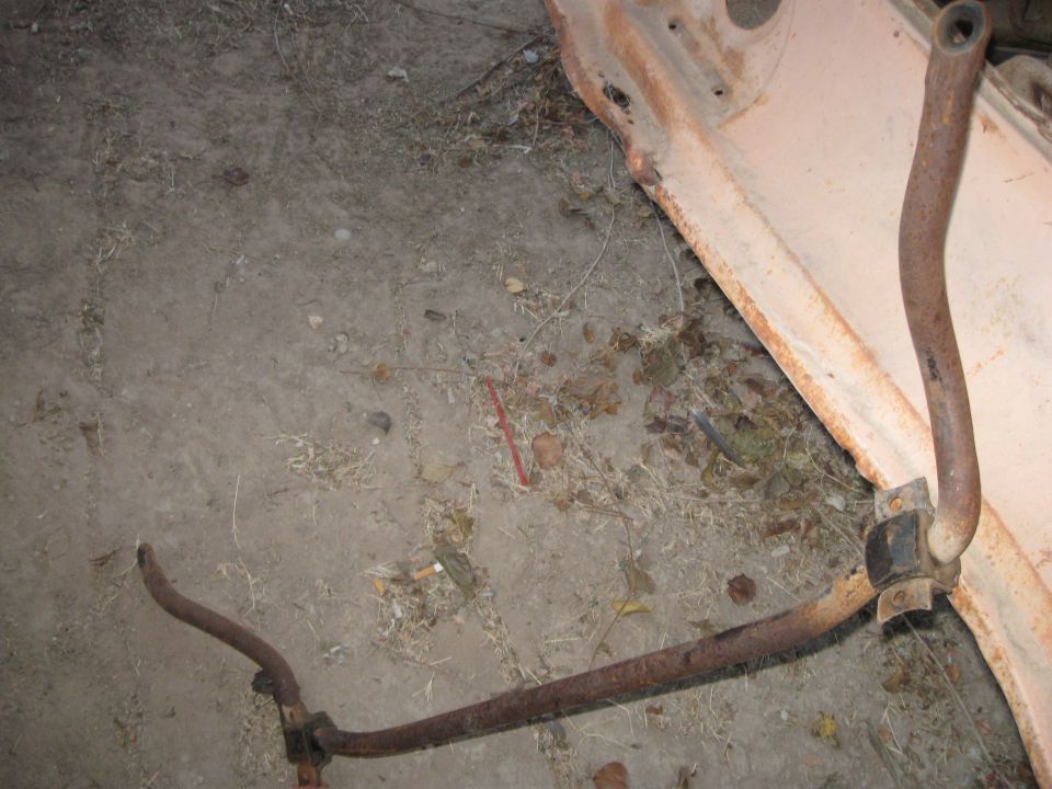 Rusty suspension bar and bracket on concrete floor