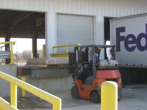 1996 Ford Bronco - A forklift is actively loading a FedEx truck at a commercial loading dock.