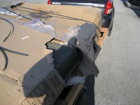 1996 Ford Bronco - Damaged cargo is secured to a trailer, with a dark SUV visible in the background.