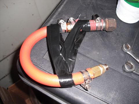1991 Ford Bronco - Custom hose adapter assembled with tape and fittings, with tools on a textured surface.