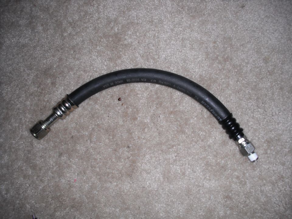 Automotive hose with metal fittings and black ribbed protective sleeves, marked GOODYEAR and P/N 3030-08
