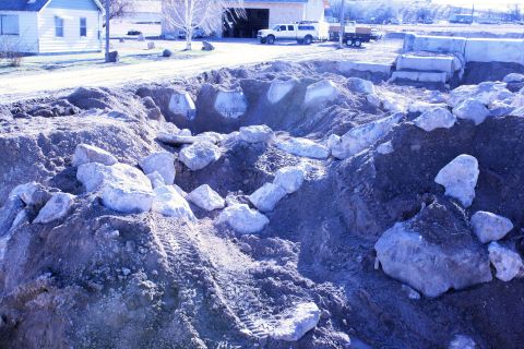 1989 Ford Bronco - Construction site with dirt piles, rocks, and tire tracks. A white pickup truck and trailer are visible in the background.