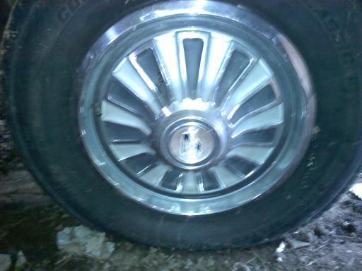 Close-up of a car wheel cover with a chrome rim and white spokes